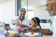 © Wavebreak Media - Biracial grandparents and granddaughter enjoy breakfast pancakes together at home