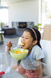 © Wavebreak Media - Biracial girl enjoys breakfast at home