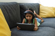 © Wavebreak Media - Biracial girl focused on a tablet at home