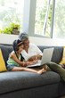 © Wavebreak Media - Biracial grandmother and granddaughter enjoy a laptop at home with copy space