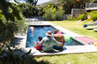 © Wavebreak Media - Biracial grandparents and granddaughter enjoy poolside fun at home with copy space
