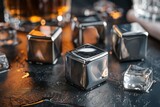 Stainless steel ice cubes on a dark surface alongside whiskey for chill and luxury beverage experience