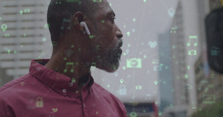 Poster - Image of networks with digital icons over african american man using smartphone in city