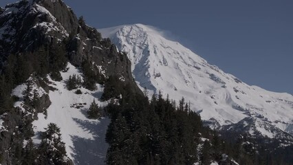 Wall Mural - Ungraded aerial drone footage of Mount Rainier National Park under light blue sky on a bright, sunny winter morning in Washington State.