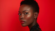 Close-up portrait of a charming young black woman with short haircut against red studio background. Beautiful African model with bright makeup and sexy appearance. Fashionable hairstyle and diversity.