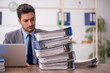 © Elnur - Young male employee and too much work in the office