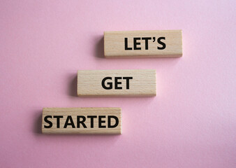 Wall Mural - lets get started symbol. concept words lets get started on wooden blocks. beautiful pink background.