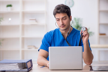 Wall Mural - Young male doctor in telemedicine concept