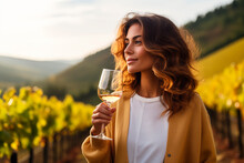 Joyful woman holding a glass of wine in a vineyard, embodying the essence of leisure and fine dining.