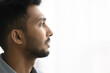Close up profile face view of pensive Indian man with attractive appearance, well-groomed beard looks into distance posing on white grey copy space background for your text. Thoughts, memories, quotes
