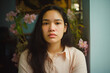 a candid portrait of a southeast asian woman with negative facial expression at home