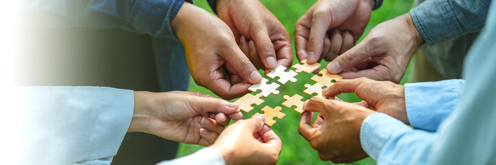 World environment day and ESG Concept of teamwork and partnership Hands join Jigsaw puzzle pieces with global community sustainable Save Earth. the Environment World Earth Day concept