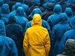 © yelosole - A person in a bright yellow coat in a crowd wearing blue symbolizing standing out and individuality