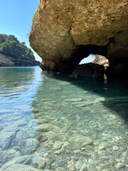 Canvas Print - Rocks in blue sea water with pebbles.