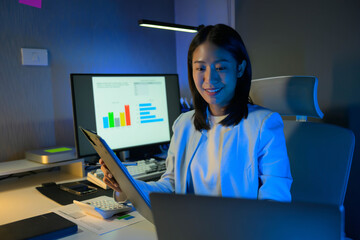 Poster - Portrait of young hardworking businesswoman working overtime during the night in her office room.