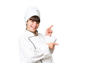 Sticker - Little caucasian chef girl over isolated background pointing finger to the side and presenting a product