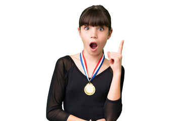 Wall Mural - Little caucasian girl with medals over isolated background thinking an idea pointing the finger up