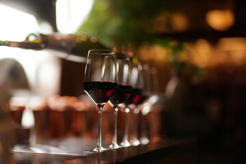 Wine glasses in a row on a bar counter, close-up.