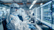 © suriya - Industrial Engineer or Scientist Working  in Clean Sterile Coveralls Using a Microscope, Developing Advanced Solutions for High-Tech Medical Vaccine and Gene Research