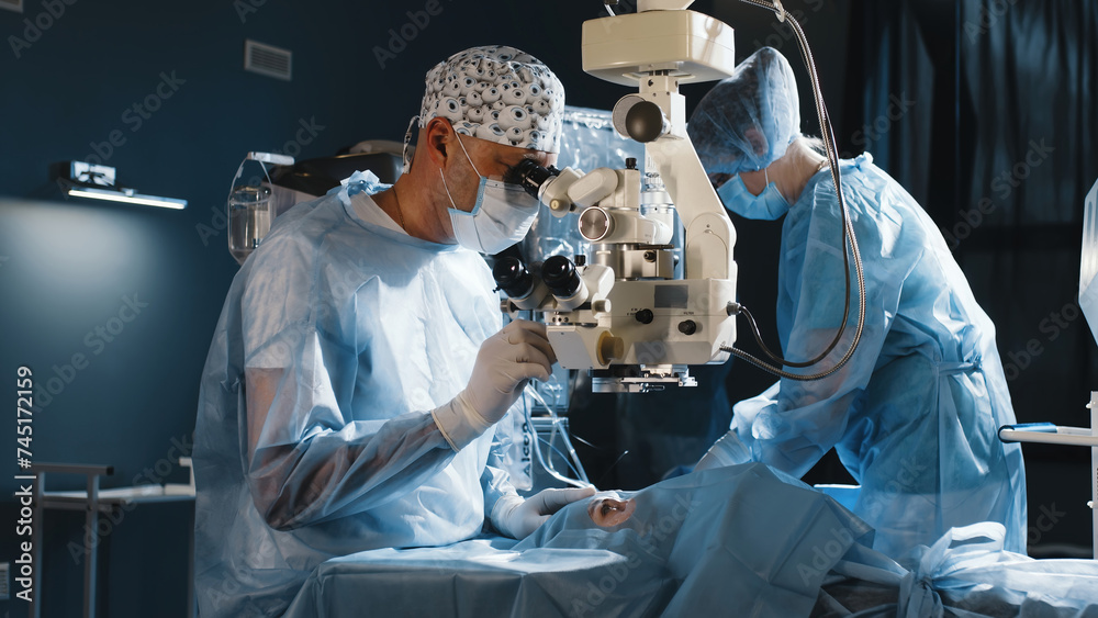 A surgeon looks through a microscope in the operating room. A doctor ...