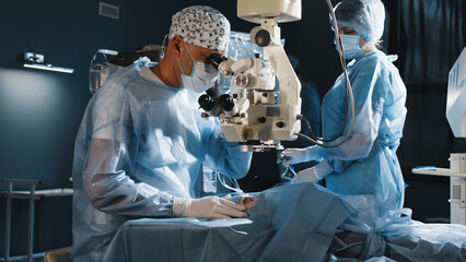 Wall Mural - A surgeon looks through a microscope in the operating room. A doctor uses a microscope during eye surgery or diagnosis, cataract treatment and diopter correction.