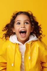 Poster - A young girl in a yellow jacket making a funny face. Suitable for various playful and cheerful concepts