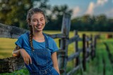 Fototapeta  - Young Female Farmer Leaning on a Wooden Fence with a Smile at a Farm in Embleton, North East England
