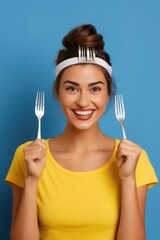 Poster - Woman holding a fork and a knife in front of her face, suitable for restaurant or cooking concepts