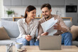 © Prostock-studio - Smiling european spouses reviewing documents in front of laptop