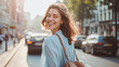 Joyful young woman with a carefree smile walking on a bustling city street, enjoying urban life.