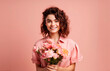 © Evgenia - Girl with a bouquet of flowers isolated on pink background. March 8, International Women's Day concept. generative AI