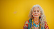 middle-aged woman smiling and looking directly at the camera. smile radiates warmth and kindness. atmosphere of trust, human emotionality and supporting positive mood. Banner. Copy space. Yellow wall