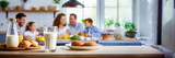 Fototapeta Kwiaty - Happy family having breakfast at home. Focus on the glass of milk, panoramic image with copy space