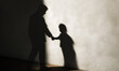 © giedriius - Disturbing image depicting the silhouette of an adult man holding hands with a child, symbolizing the dark realities of child trafficking, theft, and abuse