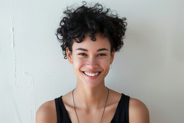 Wall Mural - Radiant Young Woman with Curly Hair Embracing Simplicity and Happiness Against a White Background