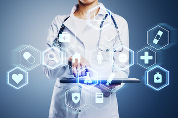 Wall Mural - Close up of female doctor hand pointing at tablet with creative glowing blue medical interface hologram on blurry background. Digital healthcare, future and research concept.