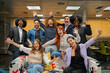 © JoseIMartin - Diverse office team jubilantly raises hands in celebration, showing teamwork and happiness at work.