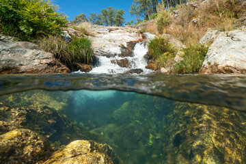 Wall Mural - Cascade in a stream seen from water surface, split view half over and under water, natural scene, Spain, Galicia, Pontevedra province