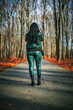 Kobieta ubrana na zielono spacerująca po lesie