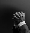© herlanzer - black man praying to god with hands together Caribbean man praying on black background with people stock photos stock photo
