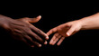 Black and white hands reaching out to each other in a gesture of support and unity