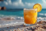 Fototapeta  - Glass with orange beverage on the sea beach
