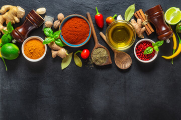 Canvas Print - Colorful food cooking ingredients background with various herbs and spices on on a dark stone background top view