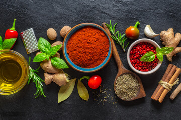 Poster - Colorful food cooking ingredients background with various herbs and spices on on a dark stone background top view