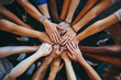 © Artoonic_Decora - Group of multiethnic people holding hands together. Diversity concept, Team members putting hands together close-up, top view, No visible faces. together. co-workers stacking their hands together.