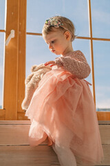 Wall Mural - little cute girl in dress near window