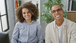 © Krakenimages.com - Two workers, a man and woman - smiling together, exuding professional success while sitting at their office table