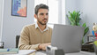 © Krakenimages.com - A handsome hispanic man with a beard working on a laptop in an office setting, exuding a professional vibe