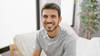 © Krakenimages.com - Handsome young hispanic man with a beard smiling in a bright bedroom interior