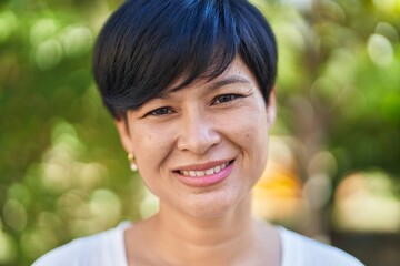 Wall Mural - Middle age chinese woman smiling confident standing at park